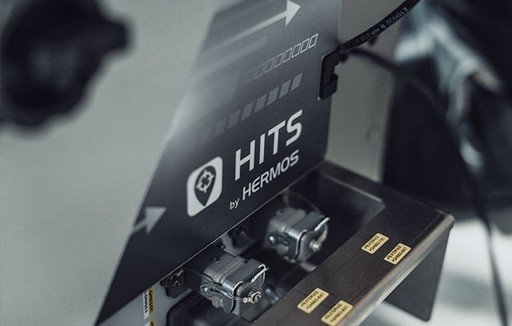 Key visual showing close-up of a HITS by HERMOS controller. 
